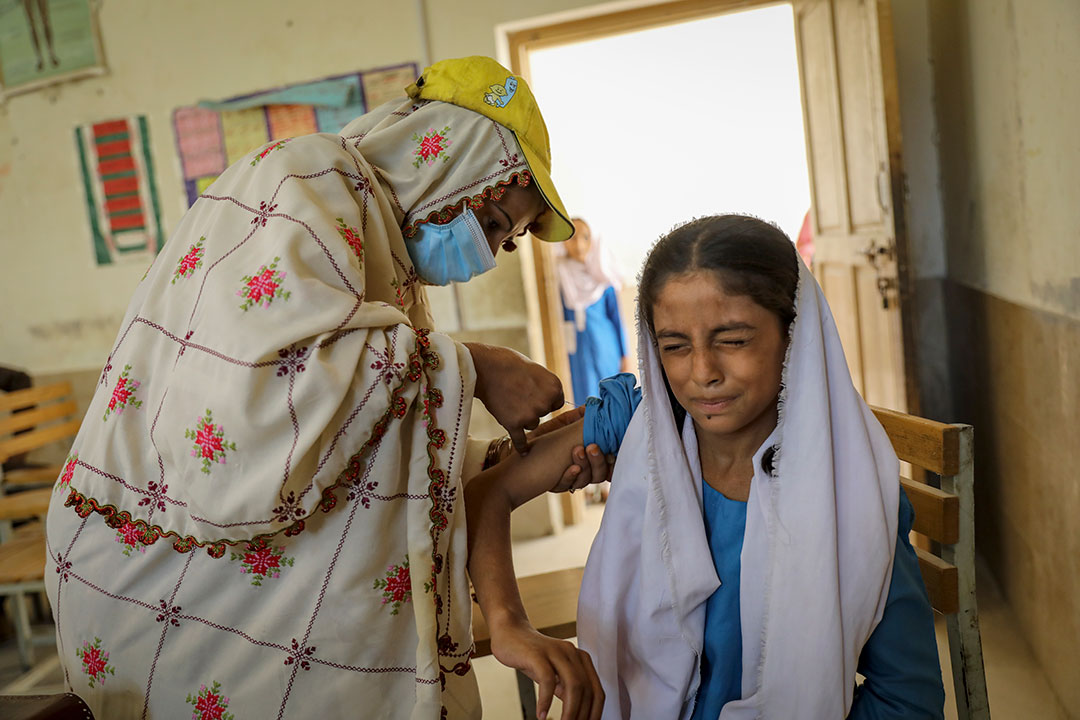 Anila, a lady health worker (LHW), administers a shot of TCV Sadiqa, aged ten, at the government girls’ middle school of Bagan Baba in Dera Allah Yar. Credit: Gavi/Asad Zaidi.