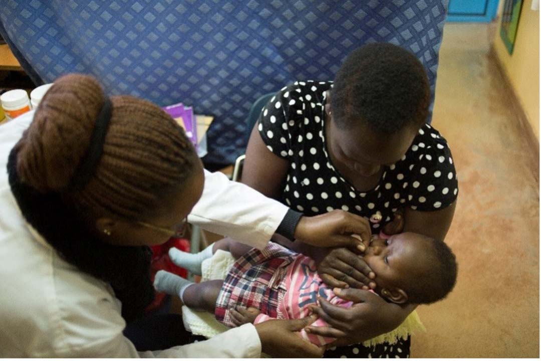 A volunteer clinician gives an infant a dose of the vaccine in Kaptembwa. Credit: Julie Mwabe, CDC Kenya