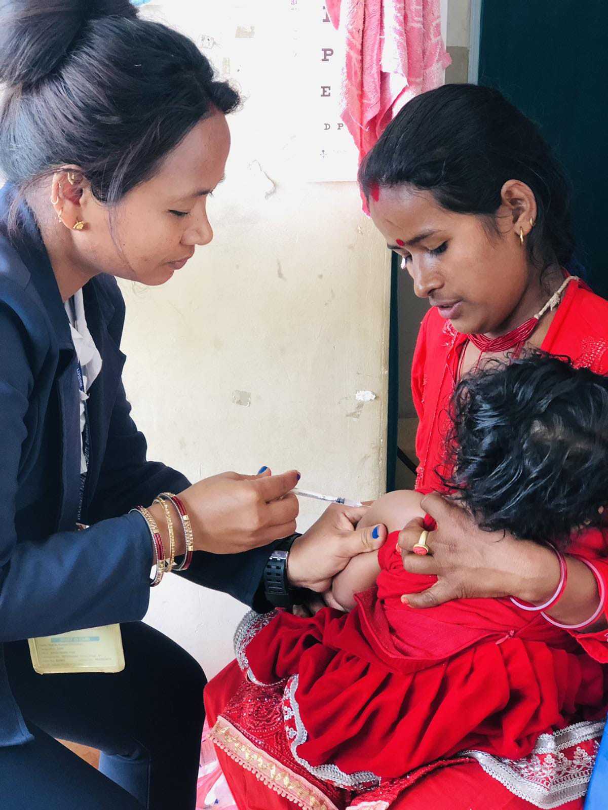 A health worker from Dhola Health Post in Jwalamukhi Rural Municipality, Dhading, administering vaccinations to children. Credit: Chhatra Karki
