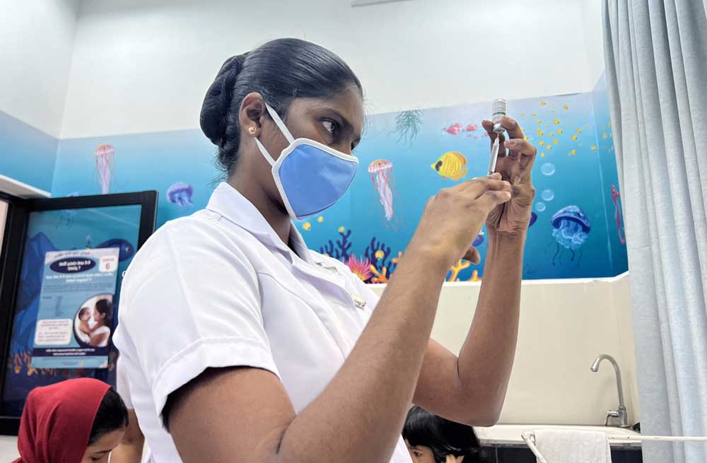 A midwife preparing a vaccine at a Maternal and Child Welfare Center in Colombo. Credit: Aanya Wipulasena