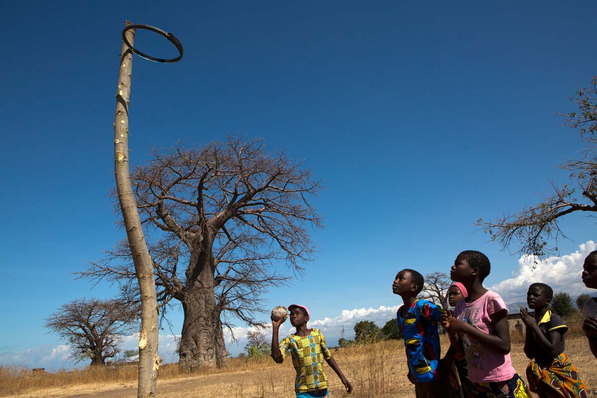 Children play netball under a baobab tree on the shore of lake Malawi near a vaccination centre. Credit: Gavi/2017/Karel Prinsloo