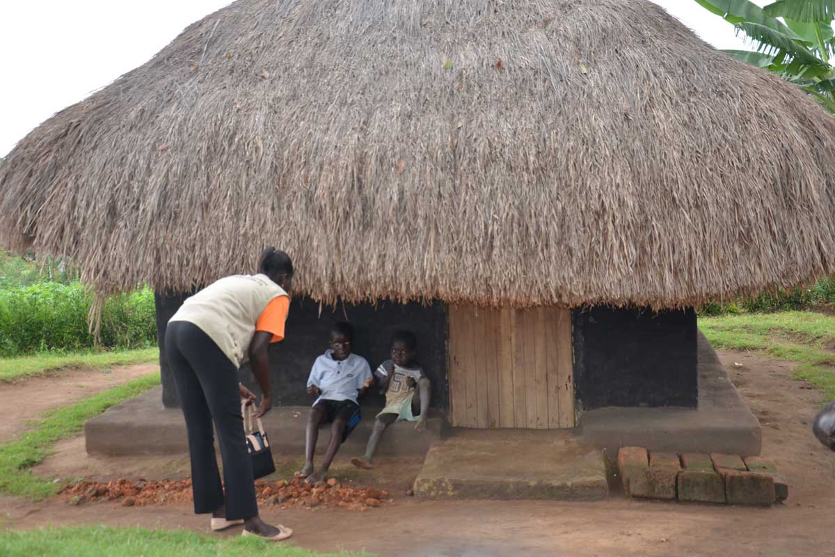 A Community Health Extension Worker interacting with children during one of the home visits in Maracha district. Credit: John Musenze