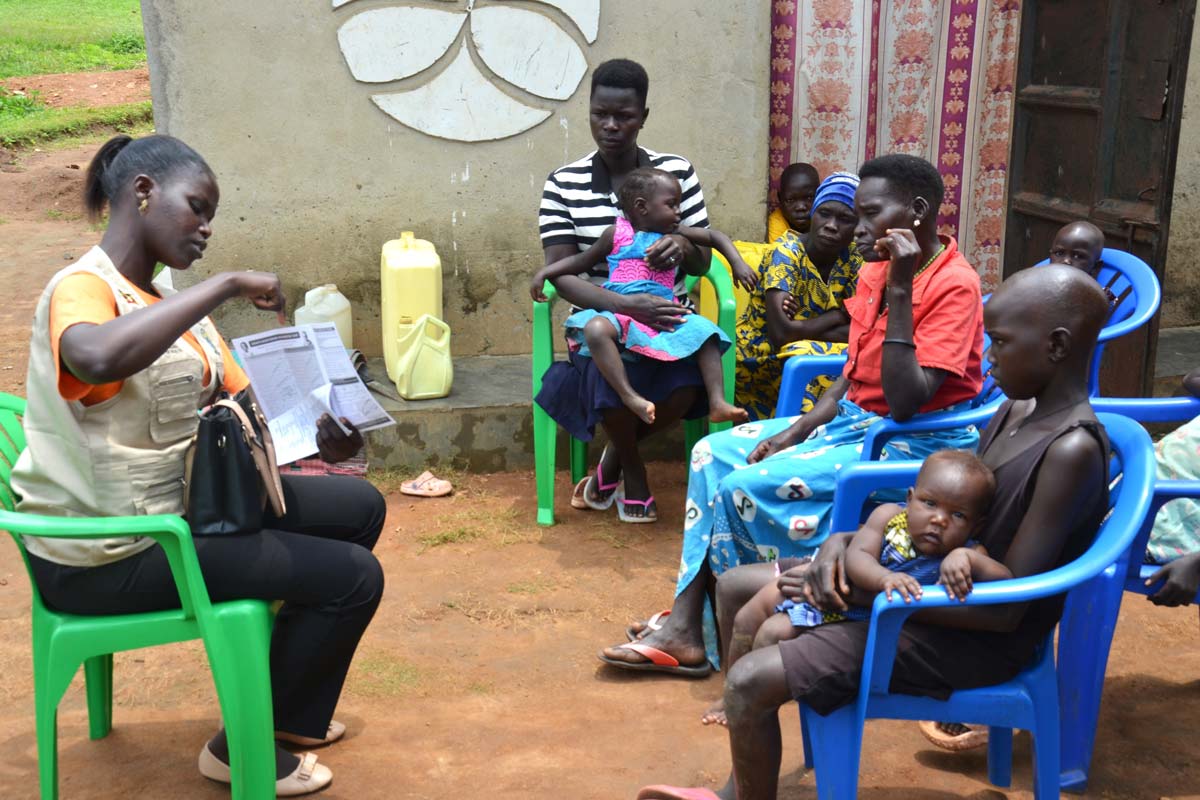 Yesco Maureen, a Community Health Extension Worker (CHEW) for Alivu parish in Maracha district guiding memebers of a family on the dates for malaria vaccination during home visits. Credit: John Musenze Yesco Maureen, a Community Health Extension Worker (CHEW) for Alivu parish in Maracha district guiding memebers of a family on the dates for malaria vaccination during home visits. Credit: John Musenze