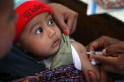 Indonesia: A health worker vaccinates a toddler against measles © UNICEF/HQ06-1800/Josh Estey